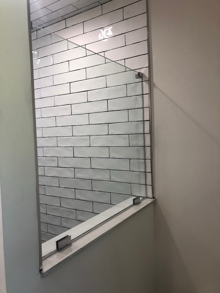 Frameless shower enclosure
